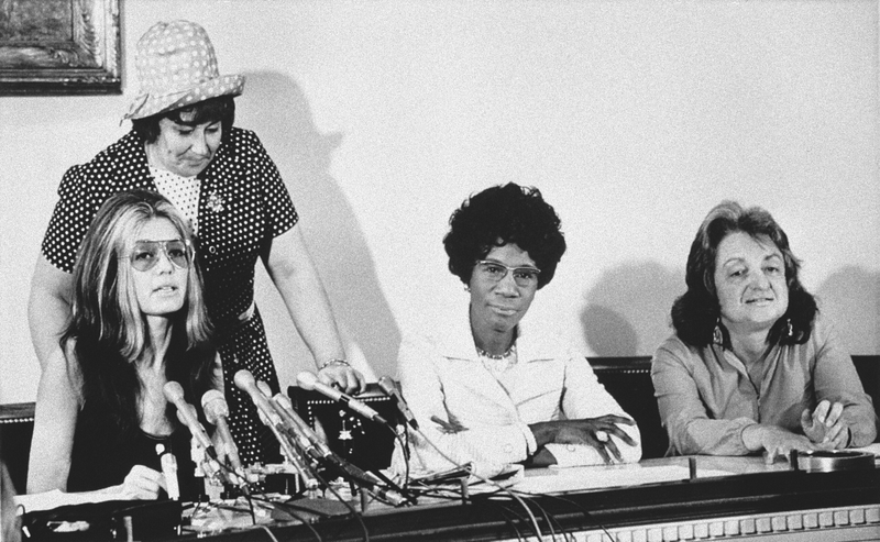 Members of the National Women’s Political Caucus tell a Washington news conference on July 12, 1971 one of their goals is that women comprise half of the delegates to the 1972 presidential conventions. Seated from left: Gloria Steinem, member of the Democratic National Policy Council; Rep. Shirley Chisholm, D-N.Y.; and Betty Friedan, women’s rights advocate. Standing is Rep. Bella Abzug, D-N.Y. Photo via AP Images.